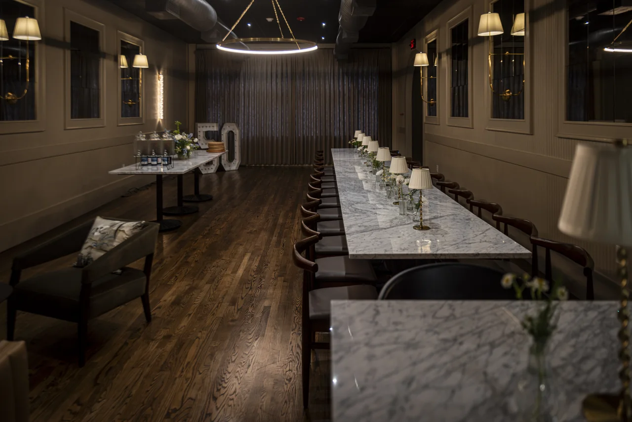 An empty restaurant dining room waits beneath warm ceiling lights.