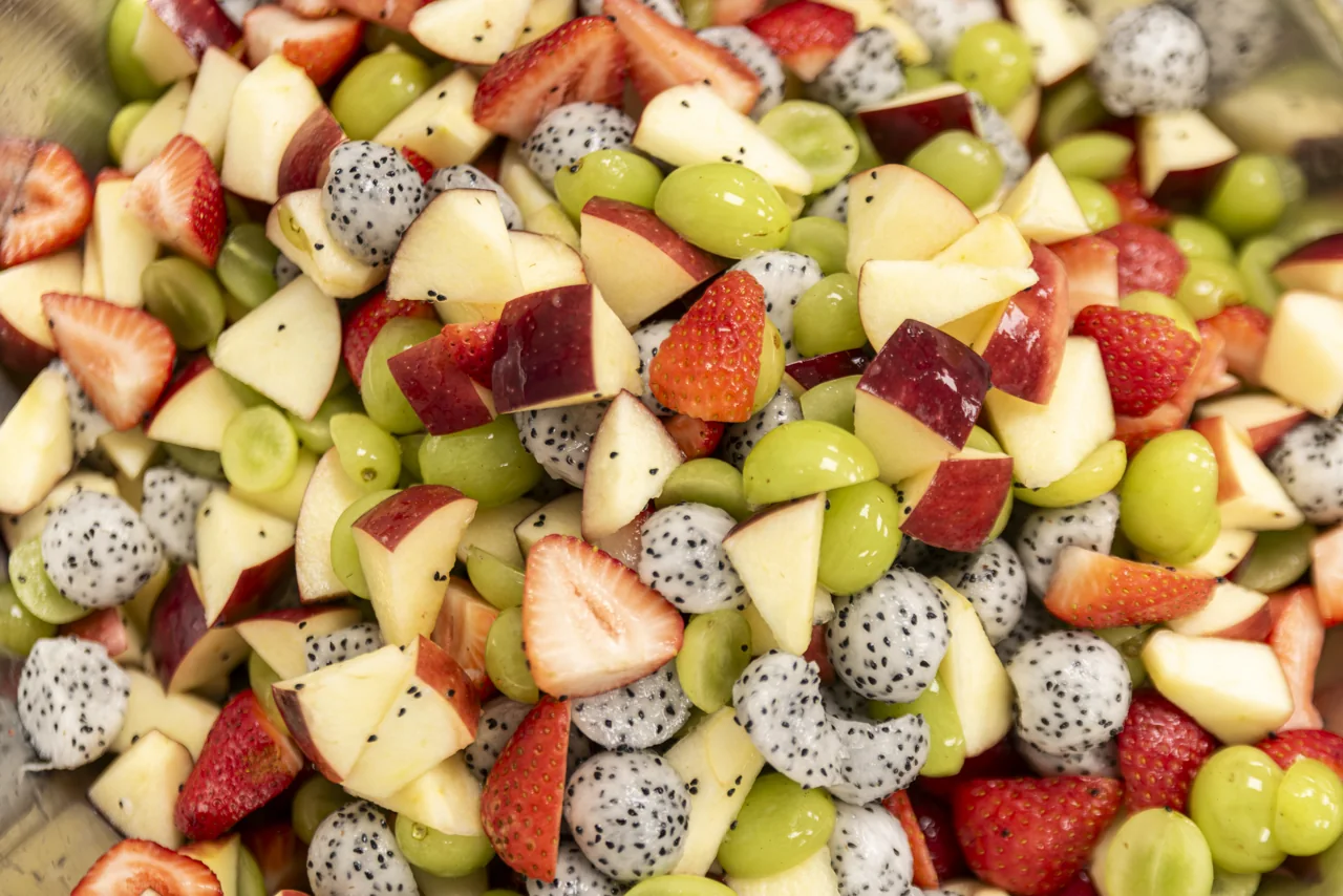 An overhead close-up reveals a bright mixture of cut fruit.
