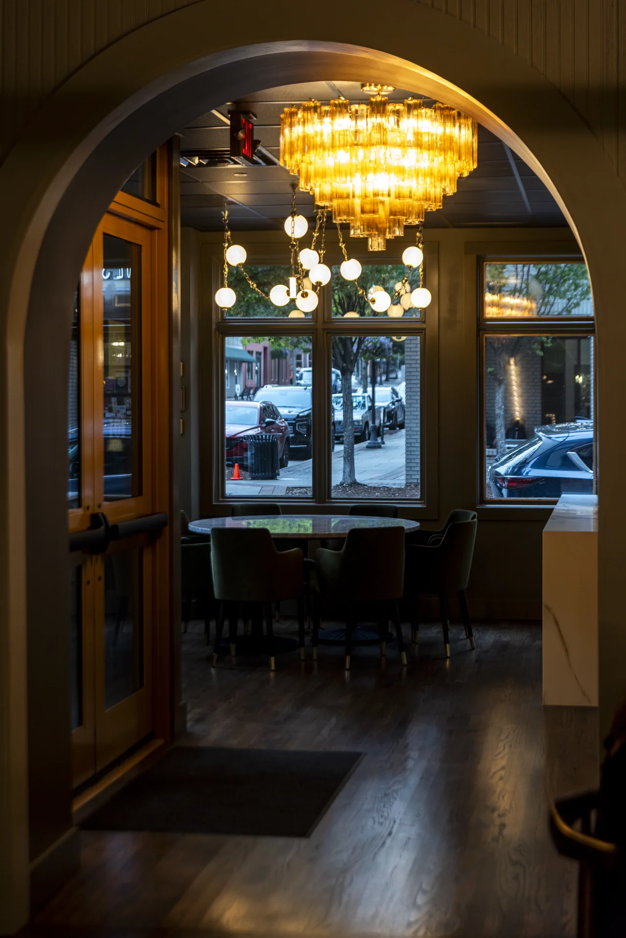 A restaurant entrance and chandelier frame the blue evening beyond.