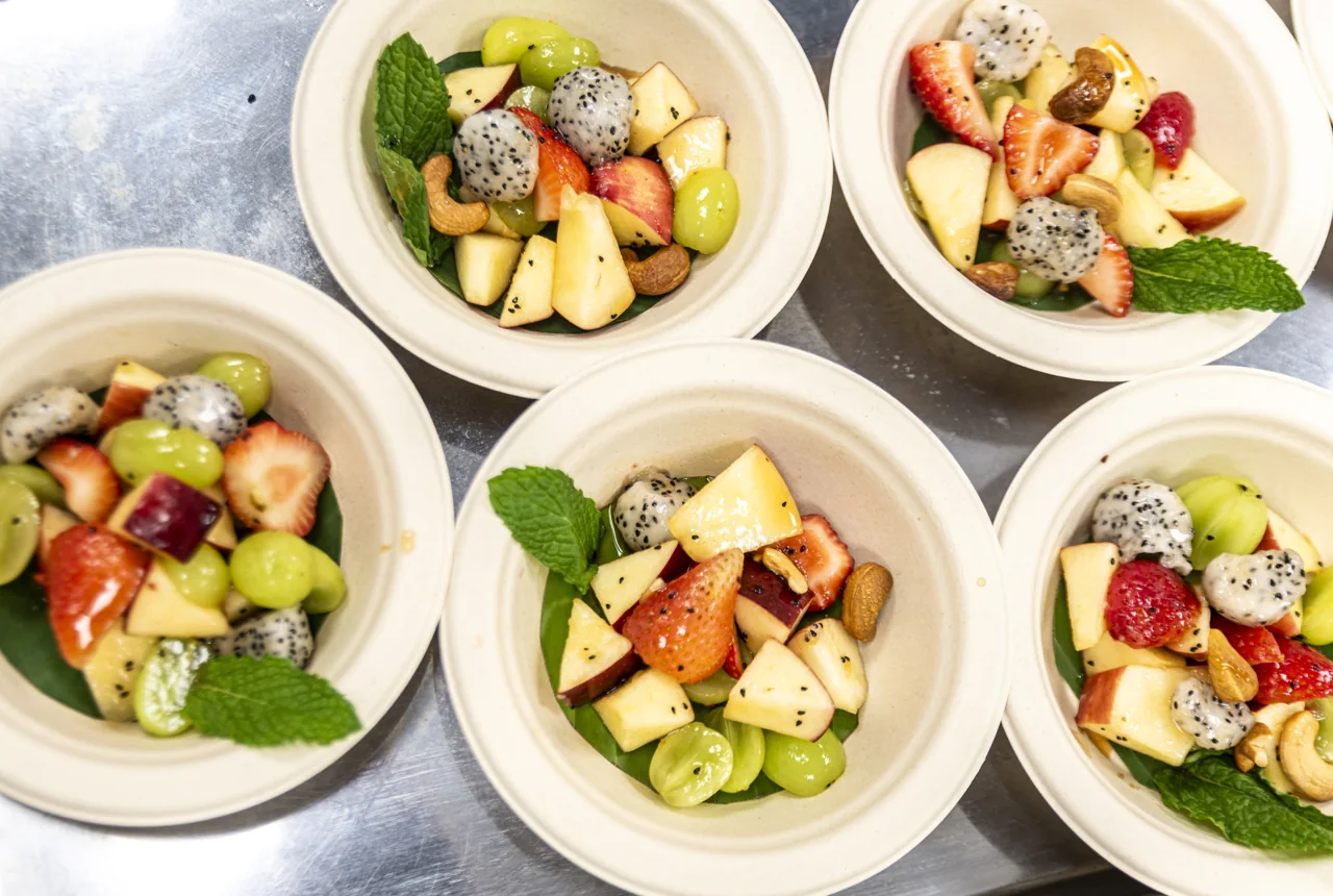 Four bowls are topped with colorful cut fruit.