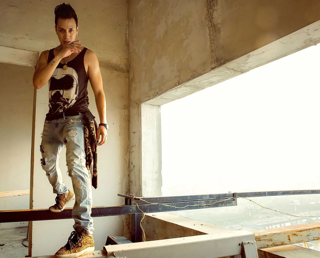 A man poses in a bare concrete architectural opening.