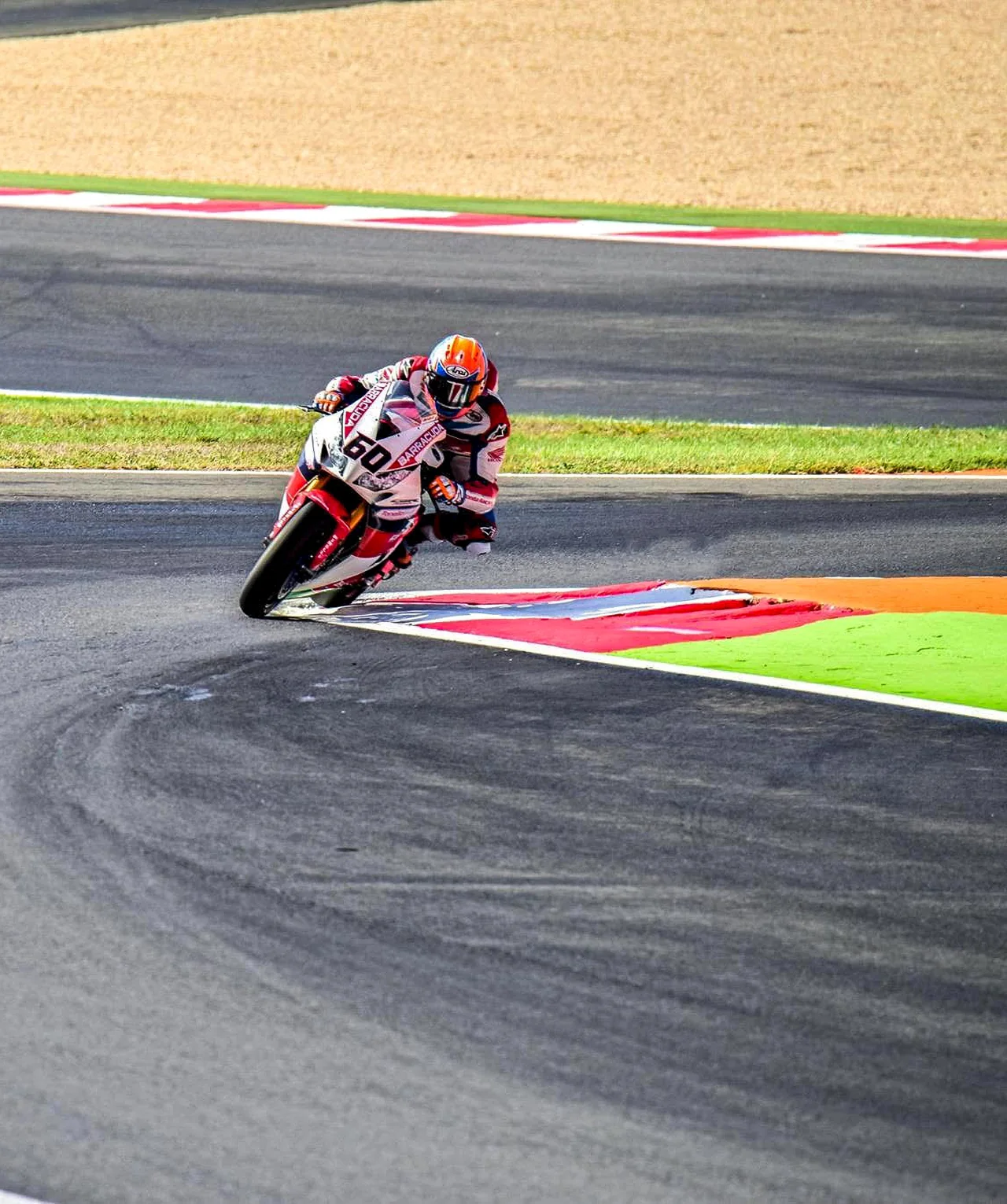 A single motorcycle racer leans low through a corner.