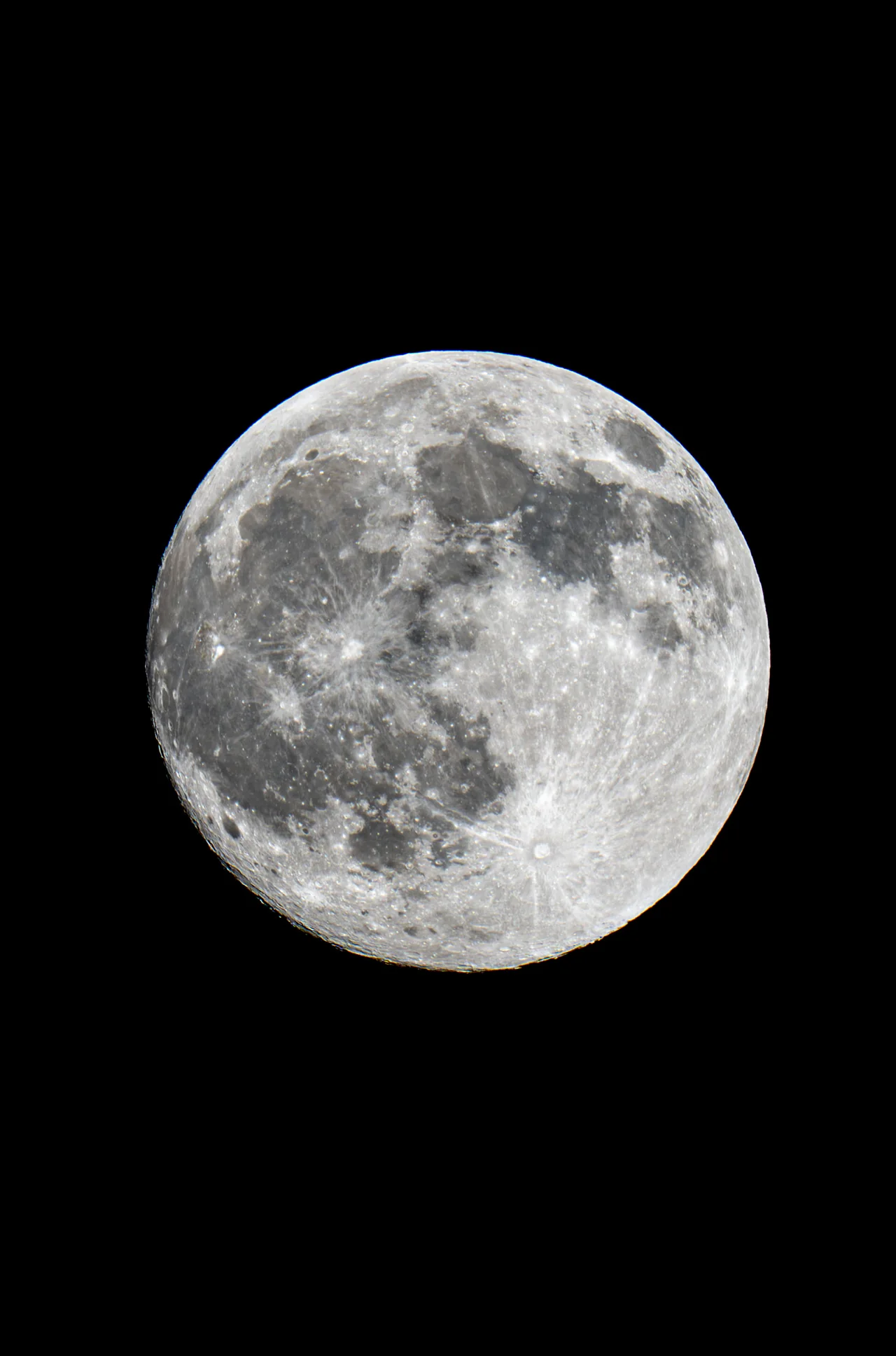 A detailed full moon appears against a black sky.